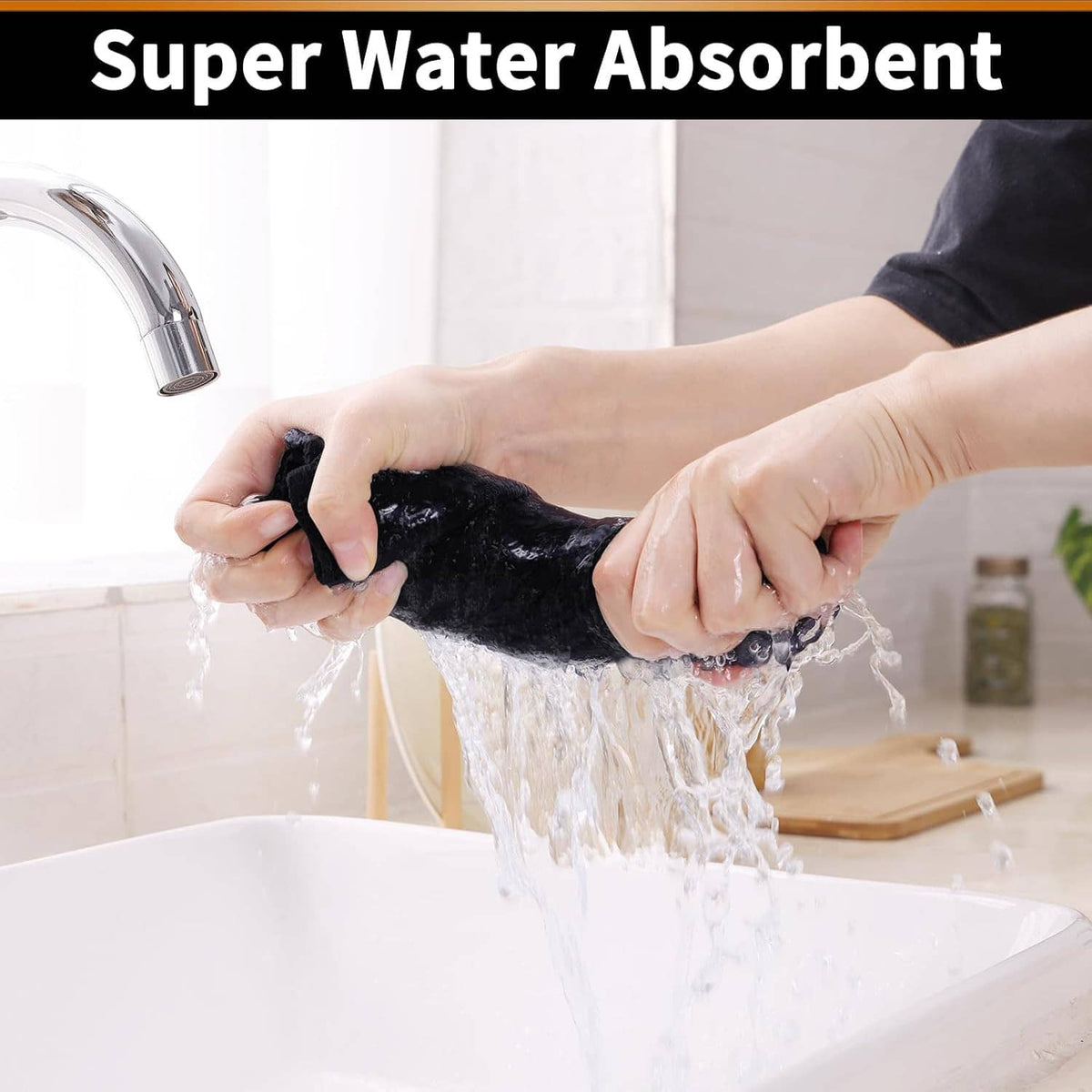 Black waffle weave cotton towel being wrung over a sink, water dripping