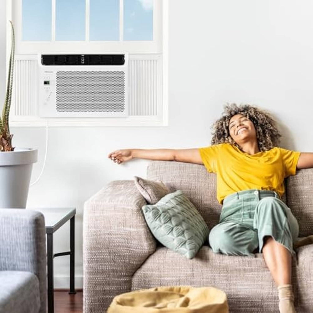 White window air conditioner installed in a window opening with side vents