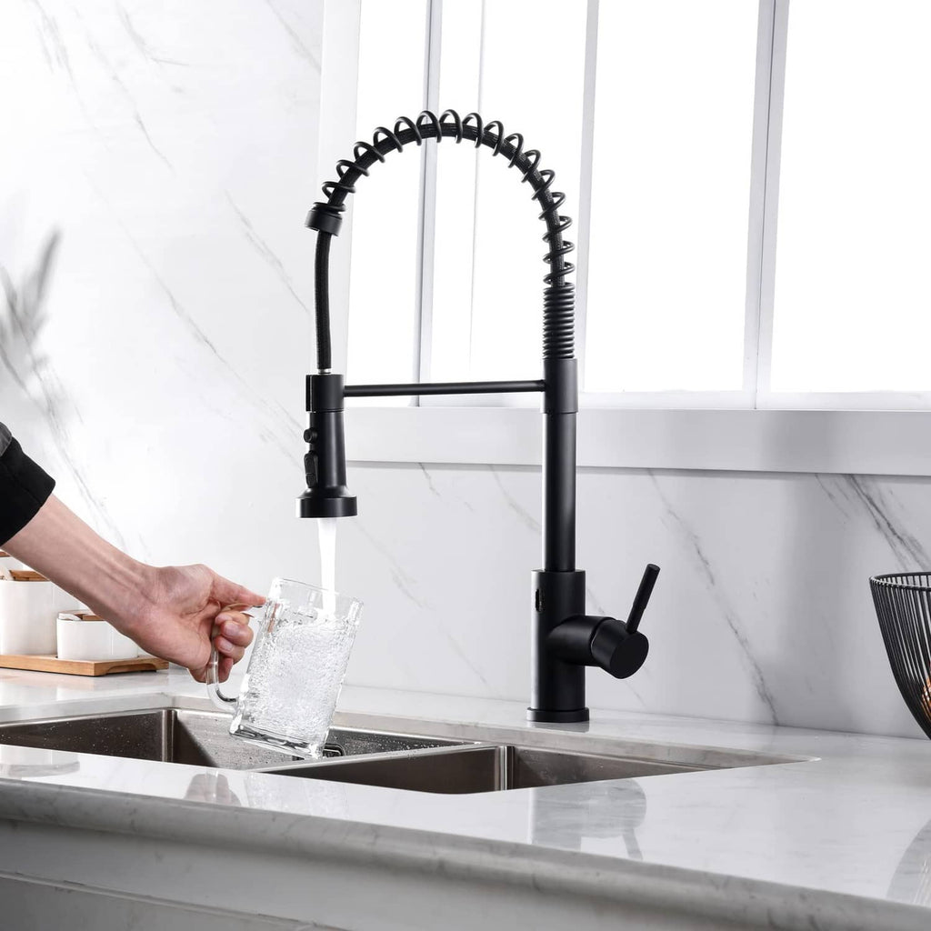 Matte black faucet sprayer pouring clear water from nozzle over kitchen sink