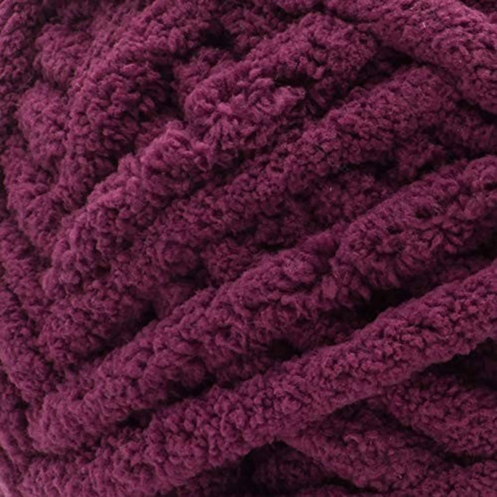 Close-up of burgundy plum chunky yarn texture with soft, looped fibers