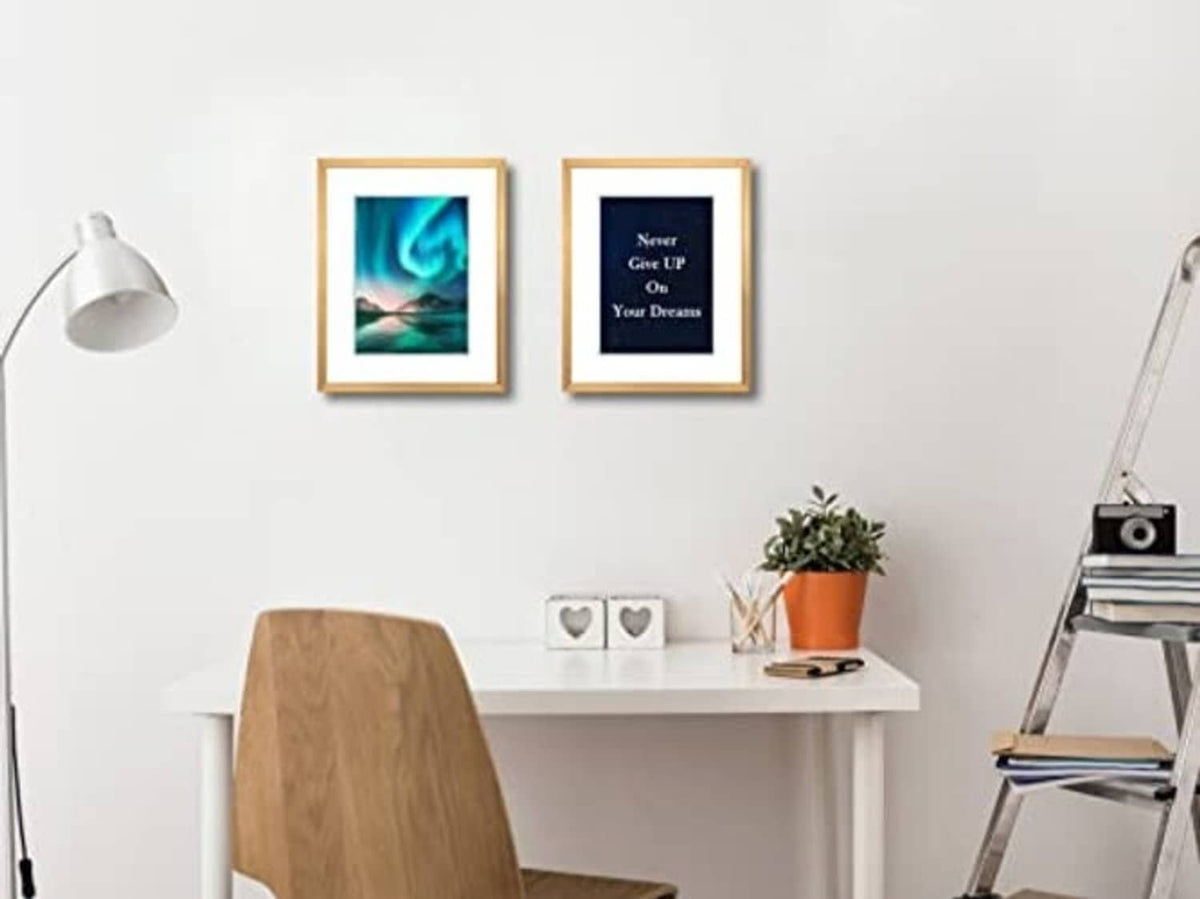 Two bronze picture frames with real glass on wall, each holding a small photo print
