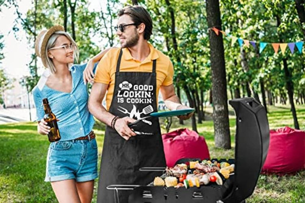 Black cotton apron with 'MR. GOOD LOOKIN' IS COOKIN' graphic, worn near grill