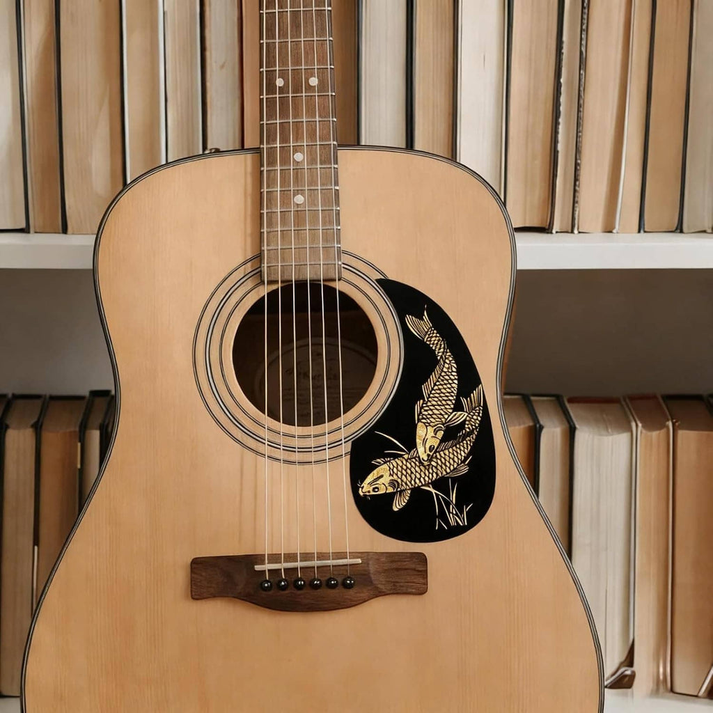 Acoustic guitar front with black teardrop pickguard sticker, gold fish motif