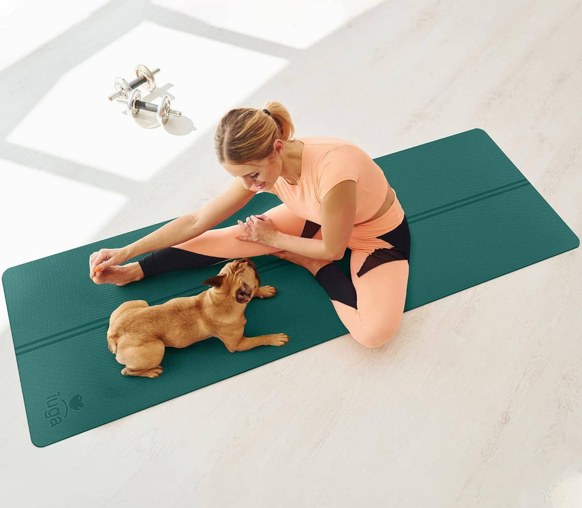 Teal yoga mat for stretching with a person and a dog on top
