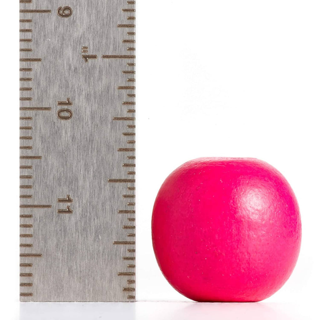 Pink round wooden bead with center hole, shown next to a measuring ruler