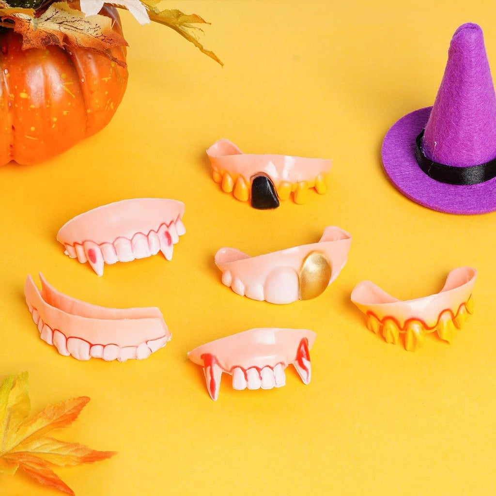 Assorted Halloween vampire fake teeth pieces, pink gums with orange and black accents