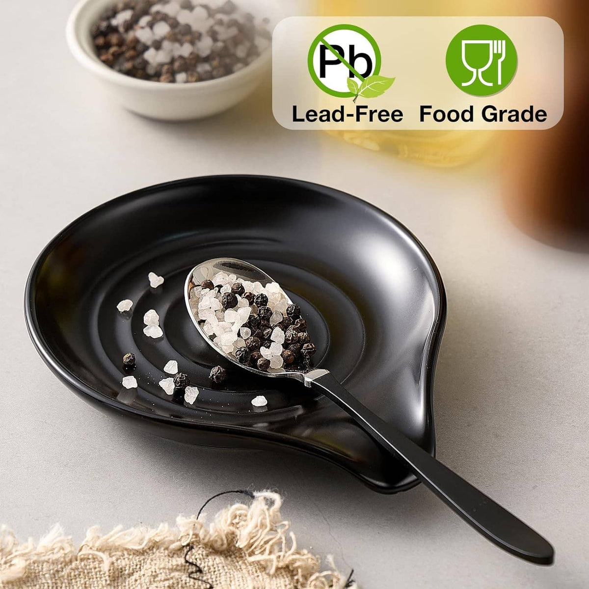 Black ceramic spoon rest with wooden spoon; small garnish pieces on holder