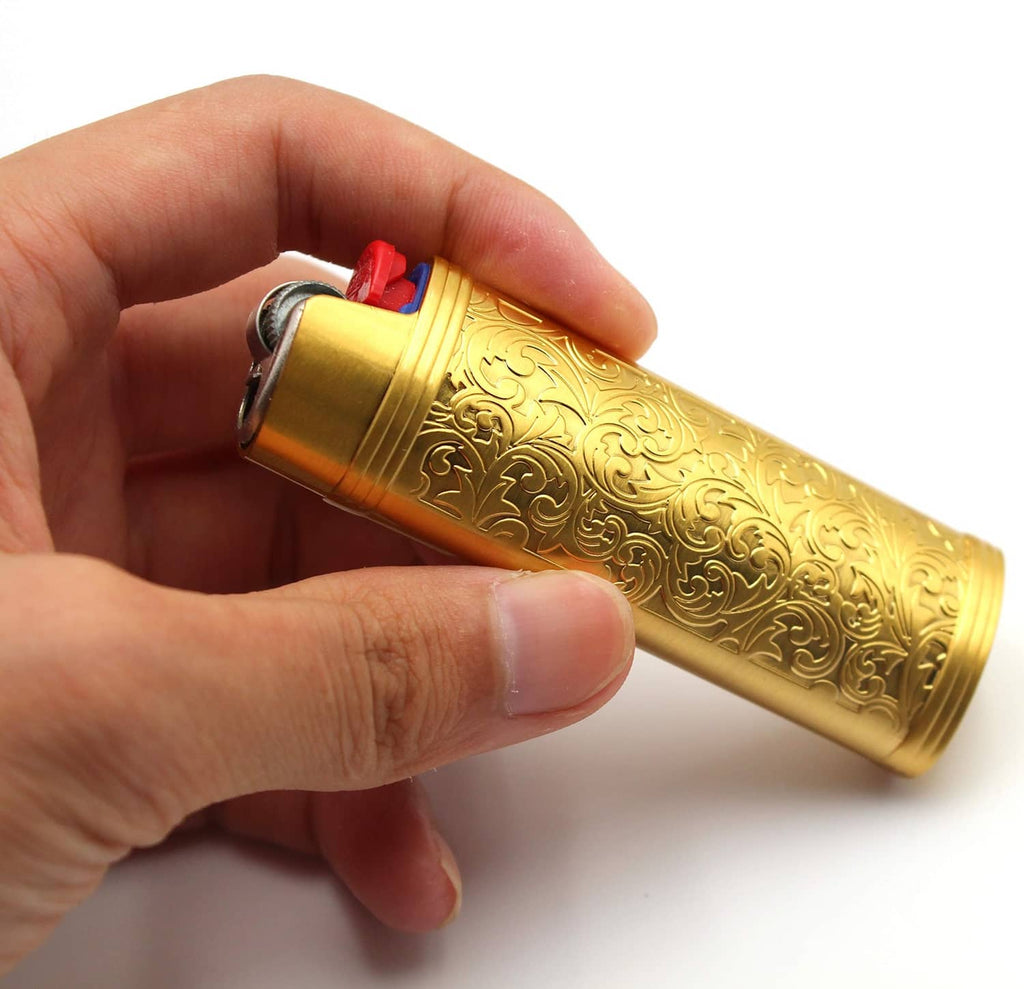 Gold metal lighter case with floral embossing held in hand; red and blue detail