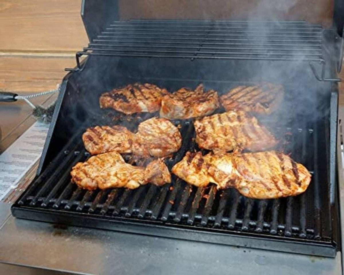 Cooked chicken on a stainless grill grate with raised bar ridges