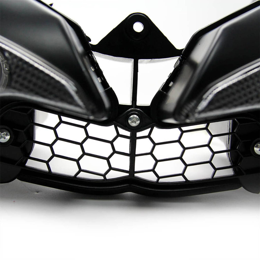 Close-up of black motorcycle headlight cowl honeycomb grille with central emblem