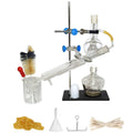 Glass home distiller setup with clamps, tube, and receiving flasks on a base