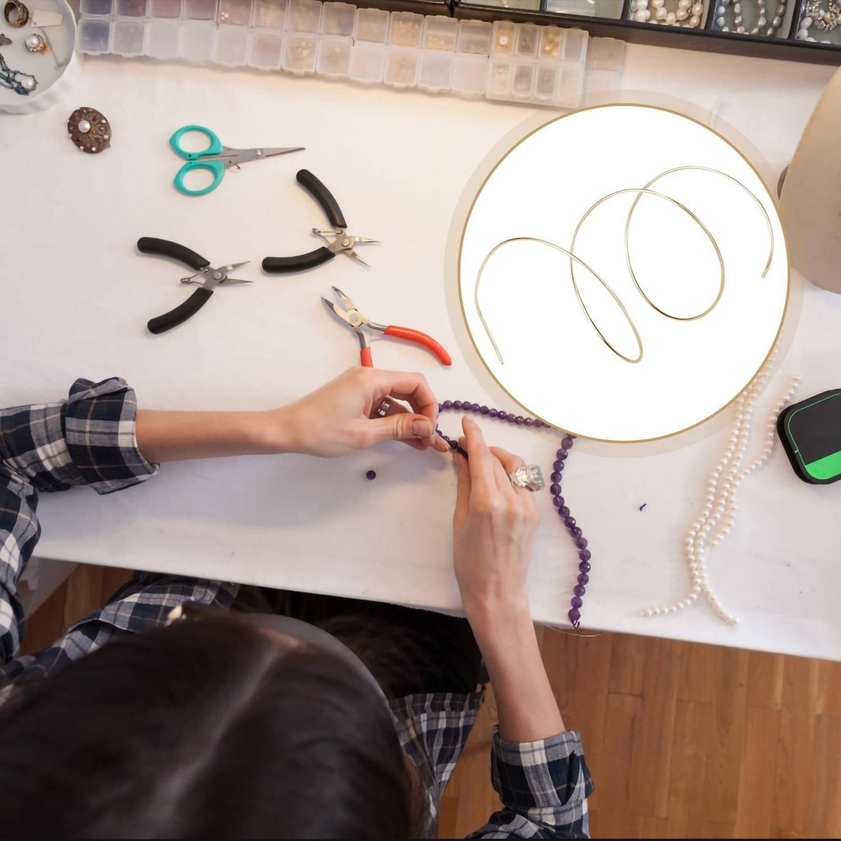 Gold-plated solder wire coil in use, held near jewelry pieces during work