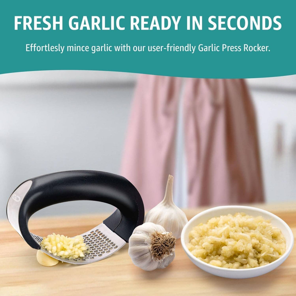 Black garlic press rocker next to bowl of minced garlic, stainless perforated plate
