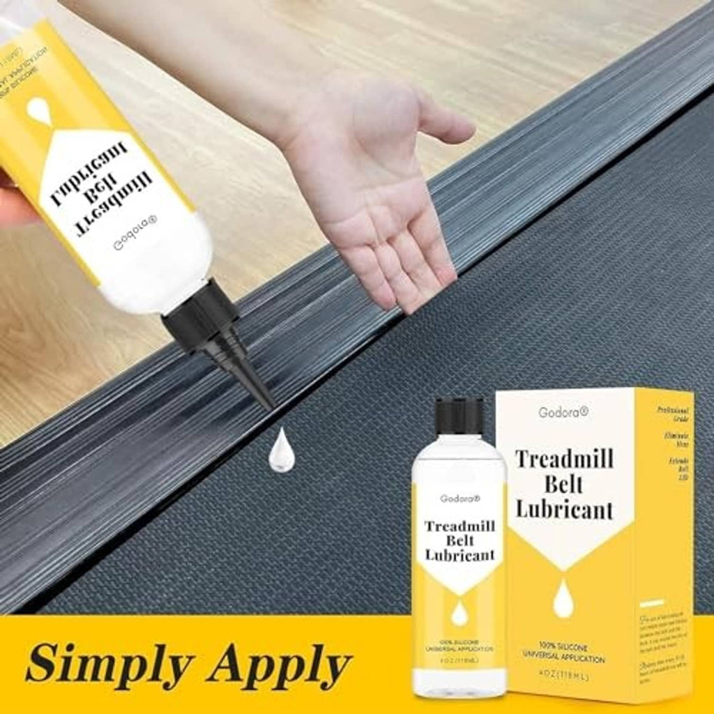 Hand applying treadmill belt lubricant along belt edge, visible drop