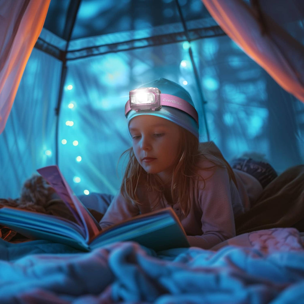 Pink kids headlamp on forehead emitting soft white light while wearing the strap.