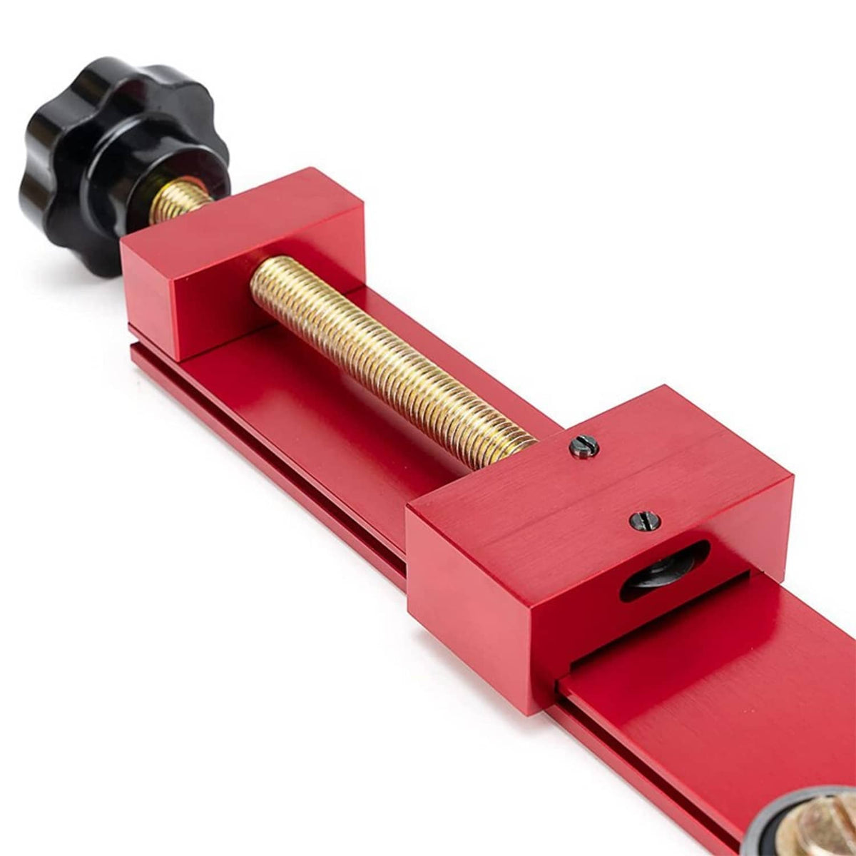 Close-up red oil filter cutter tool with threaded rod, black knob, and mounting slot