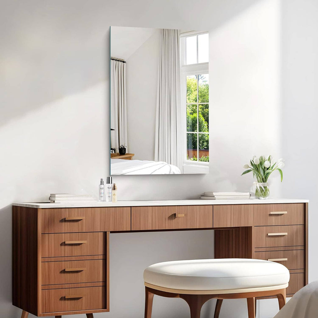 Rectangular frameless mirror mounted above sink with smooth reflective glass
