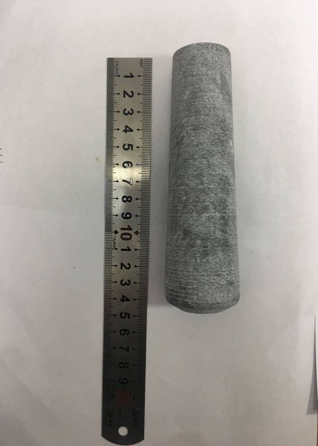 Gray pestle replacement beside a ruler, size measurement view