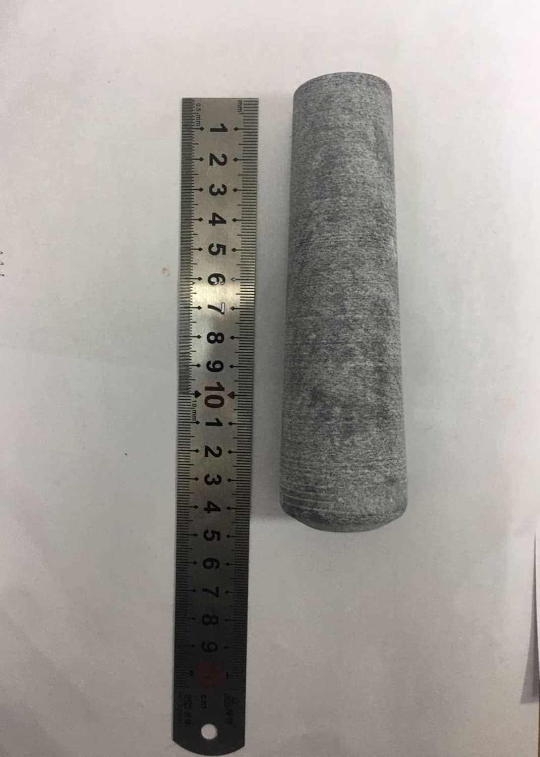 Gray pestle replacement beside a ruler, size measurement view
