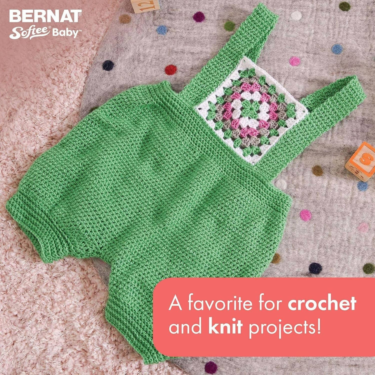 Green knit baby dress with embroidered flower square on the chest