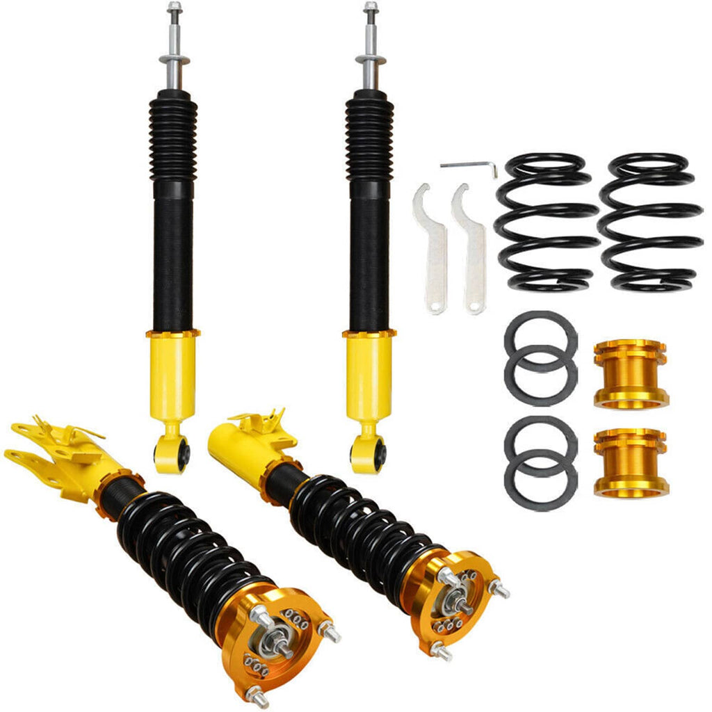 Pair of coilover shocks with black coil springs, yellow bodies, and installation accessories