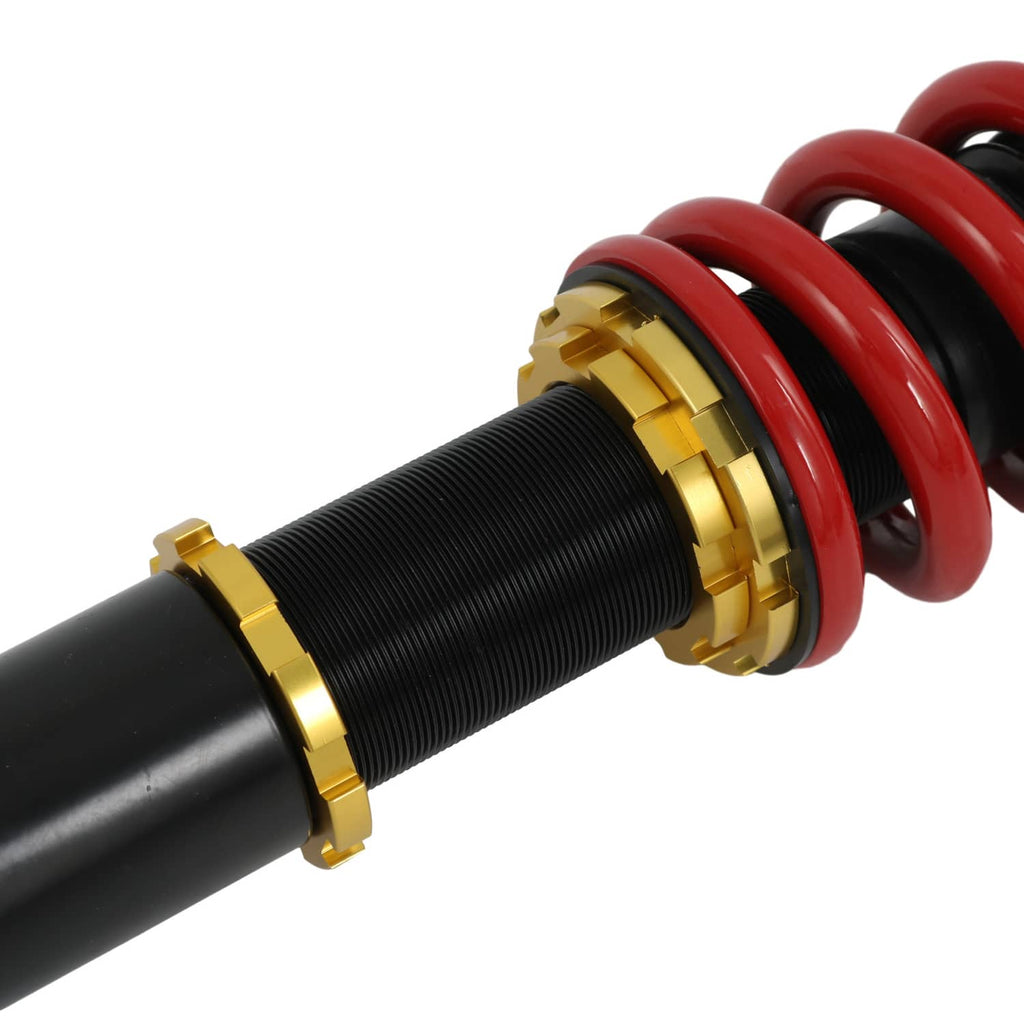 Coilover strut with red coil spring, black shock body, gold adjuster collars