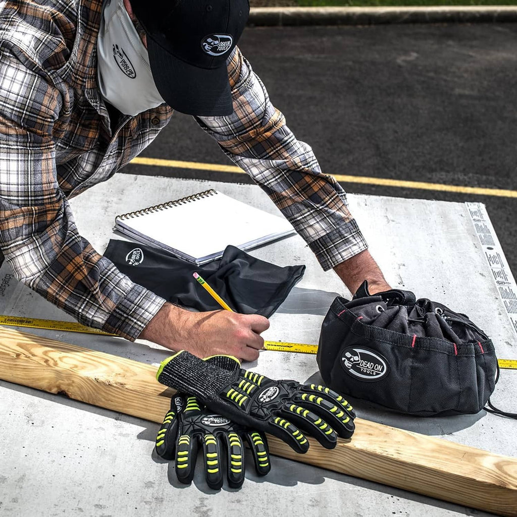 Black tools parachute bag with logo, holding gloves and hand tools on a workbench