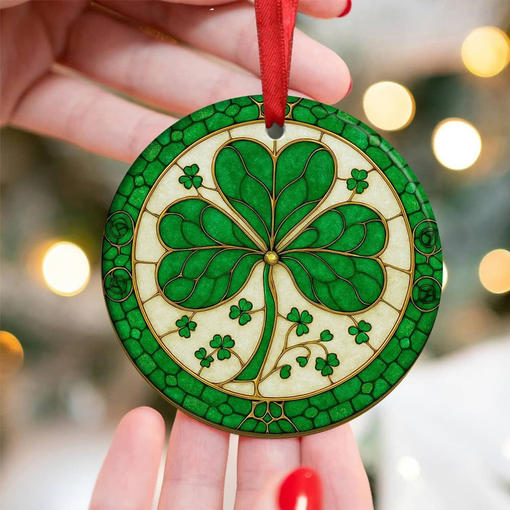 Green ceramic shamrock ornament with red ribbon, held up against a softly lit background