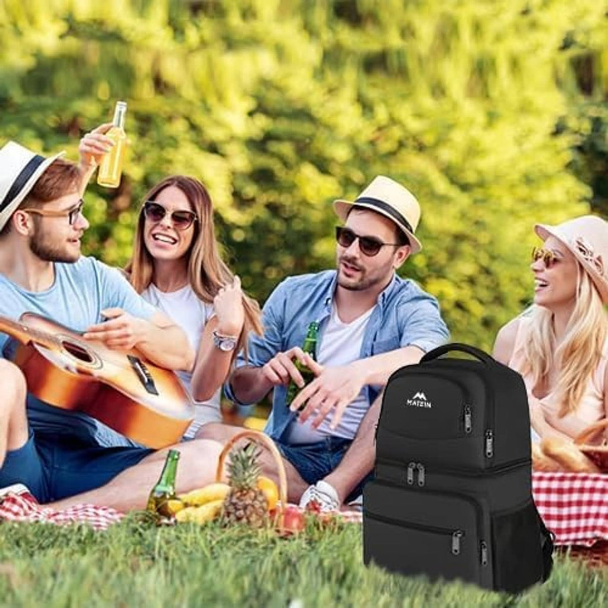 Black insulated cooler backpack worn outdoors at a picnic, with front zipper pocket.