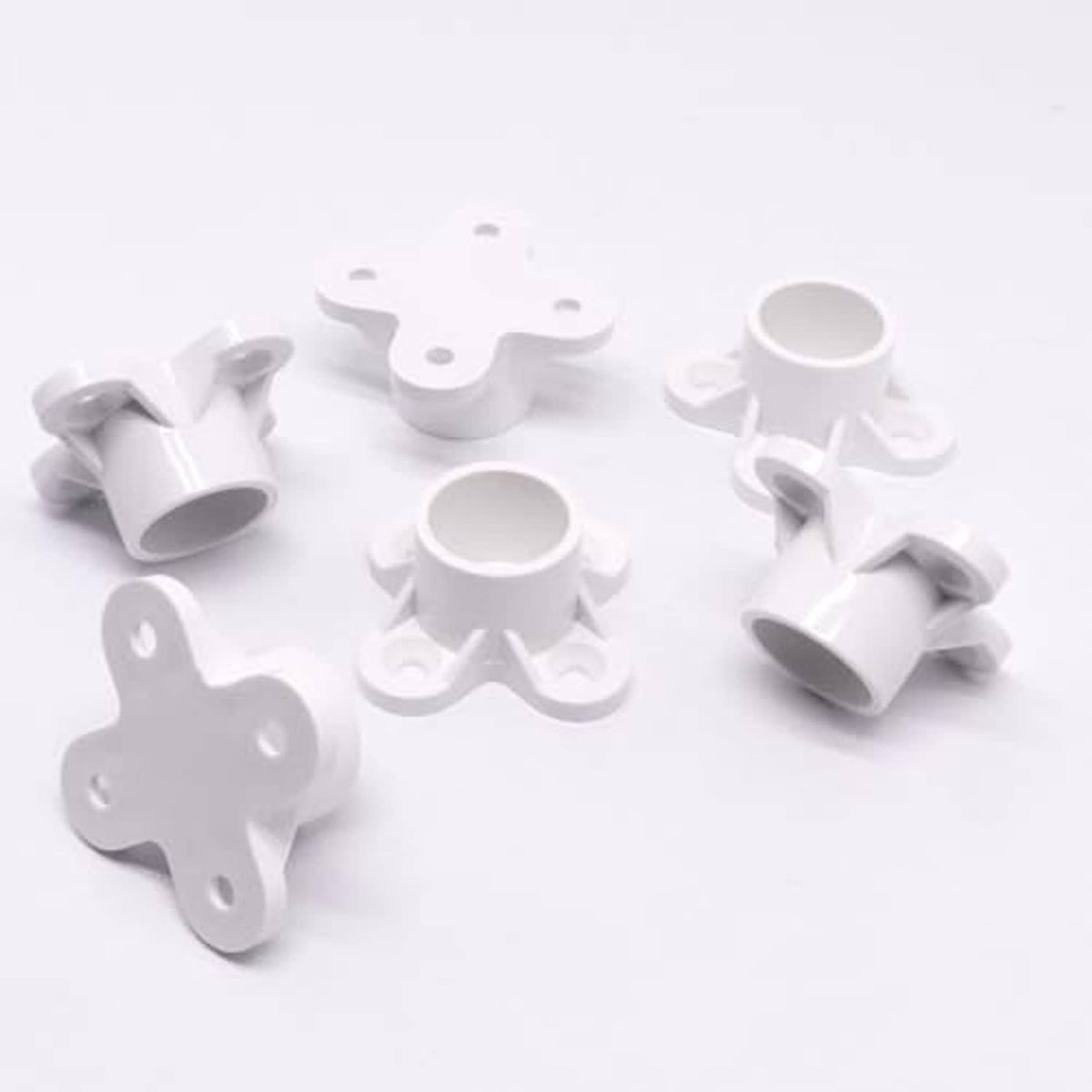 White PVC pipe flange cap fittings, several pieces shown on a tabletop