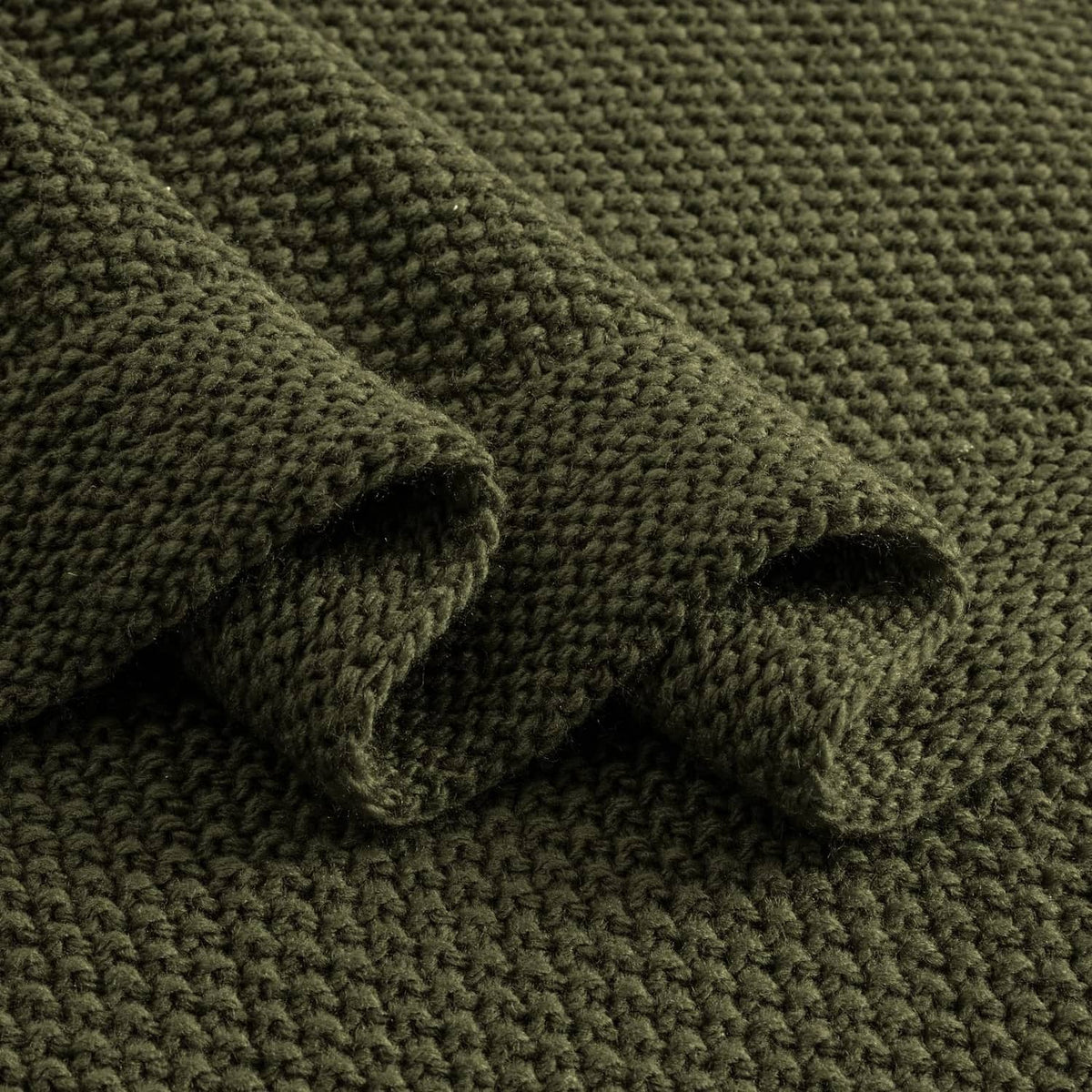 Olive green chunky knit throw blanket fabric close-up, textured weave.