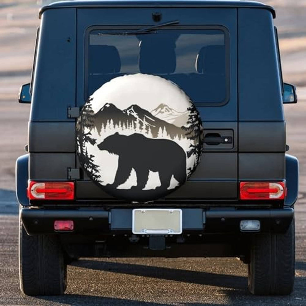 Round bear and mountain tire cover mounted on the rear spare of a blue SUV