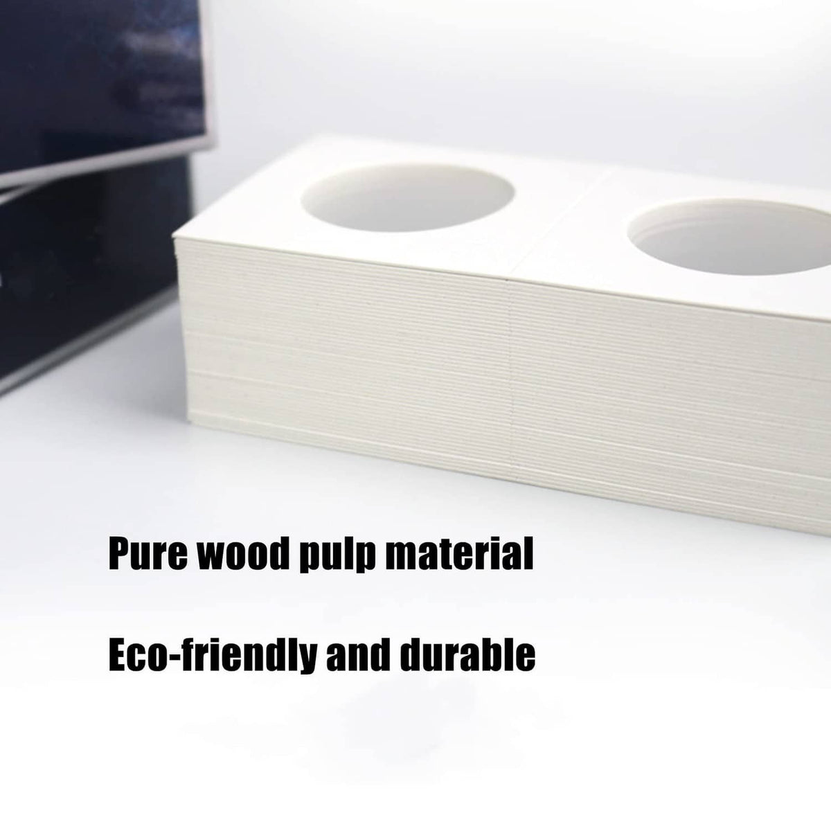 Stack of white 2x2 coin flip sleeves with round cutout openings for coins