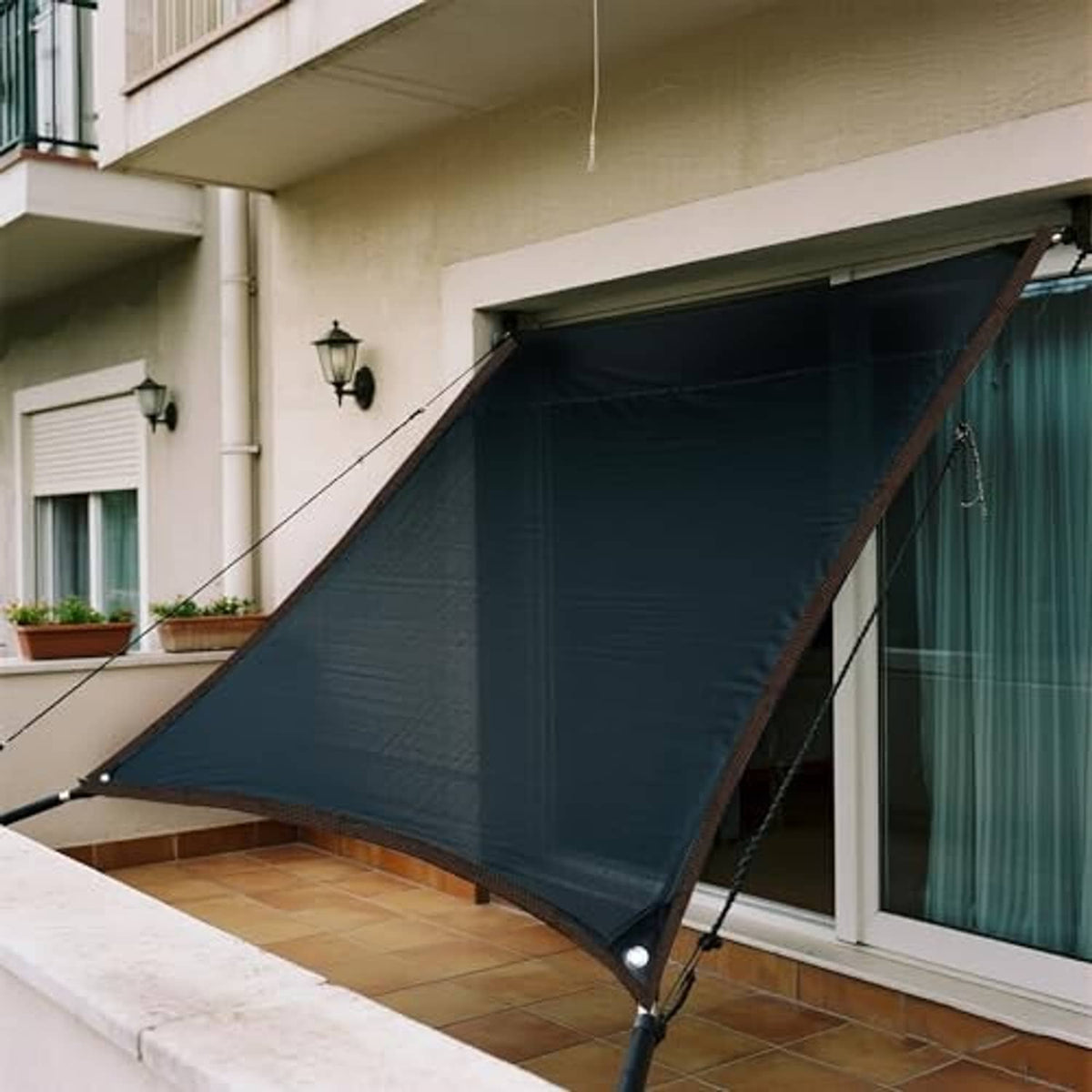 Black shade cloth tarp installed on patio, stretched across between hanging ropes
