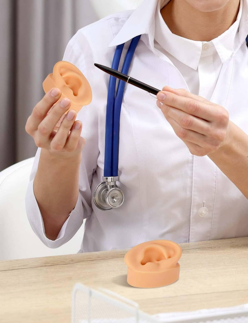 Small skin-tone silicone ear model on a work surface, realistic ear opening