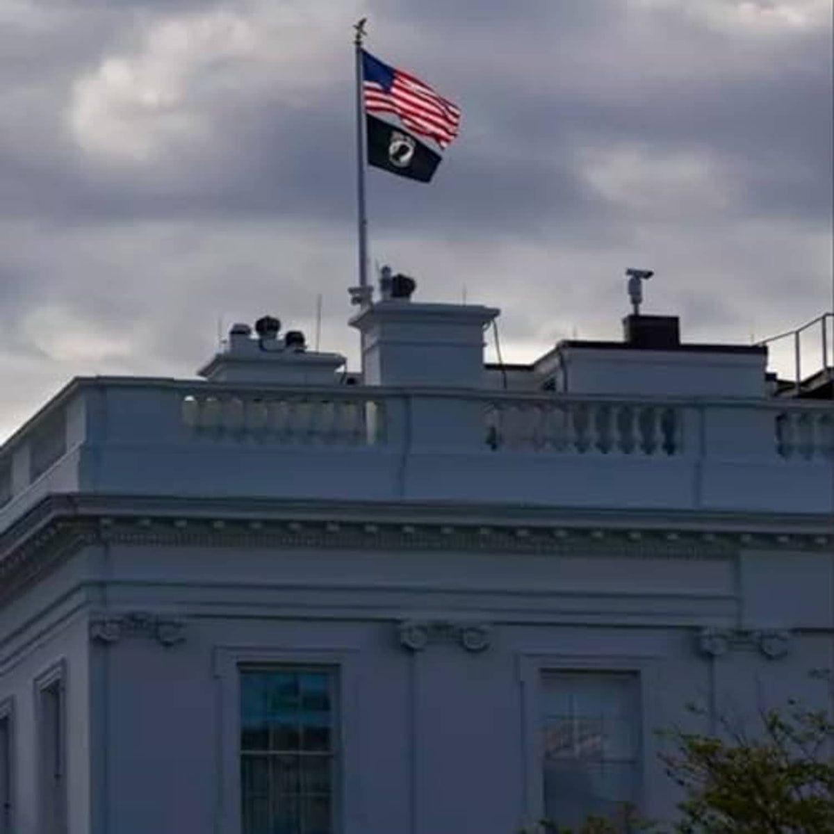 Outdoor flag on pole above building roofline