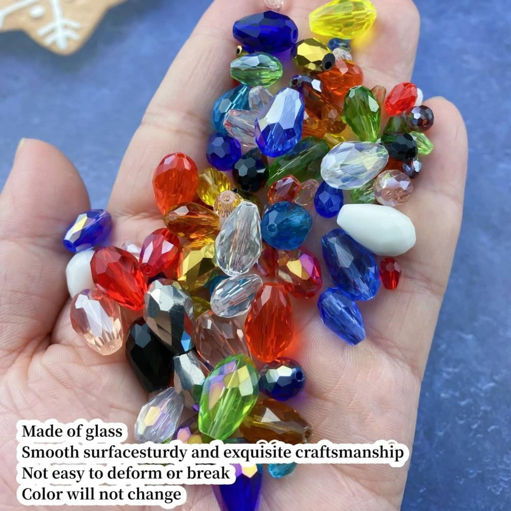 Faceted multicolor glass teardrop beads in an open palm with vertical holes