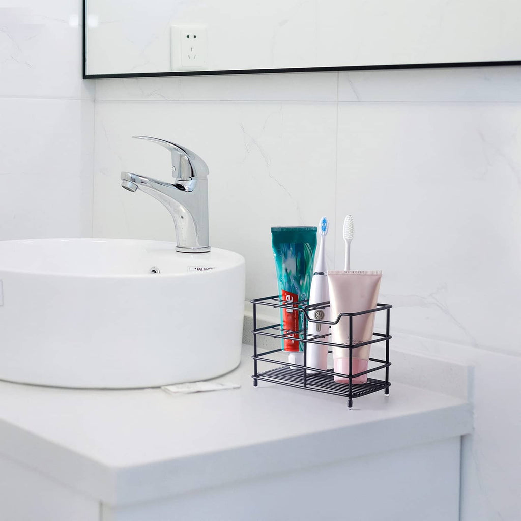 Toothbrush holder with two-tier tray beside faucet, holding toothbrushes and tubes