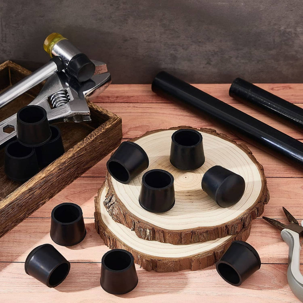 Black rubber folding chair leg caps arranged on a wooden board near a chair frame