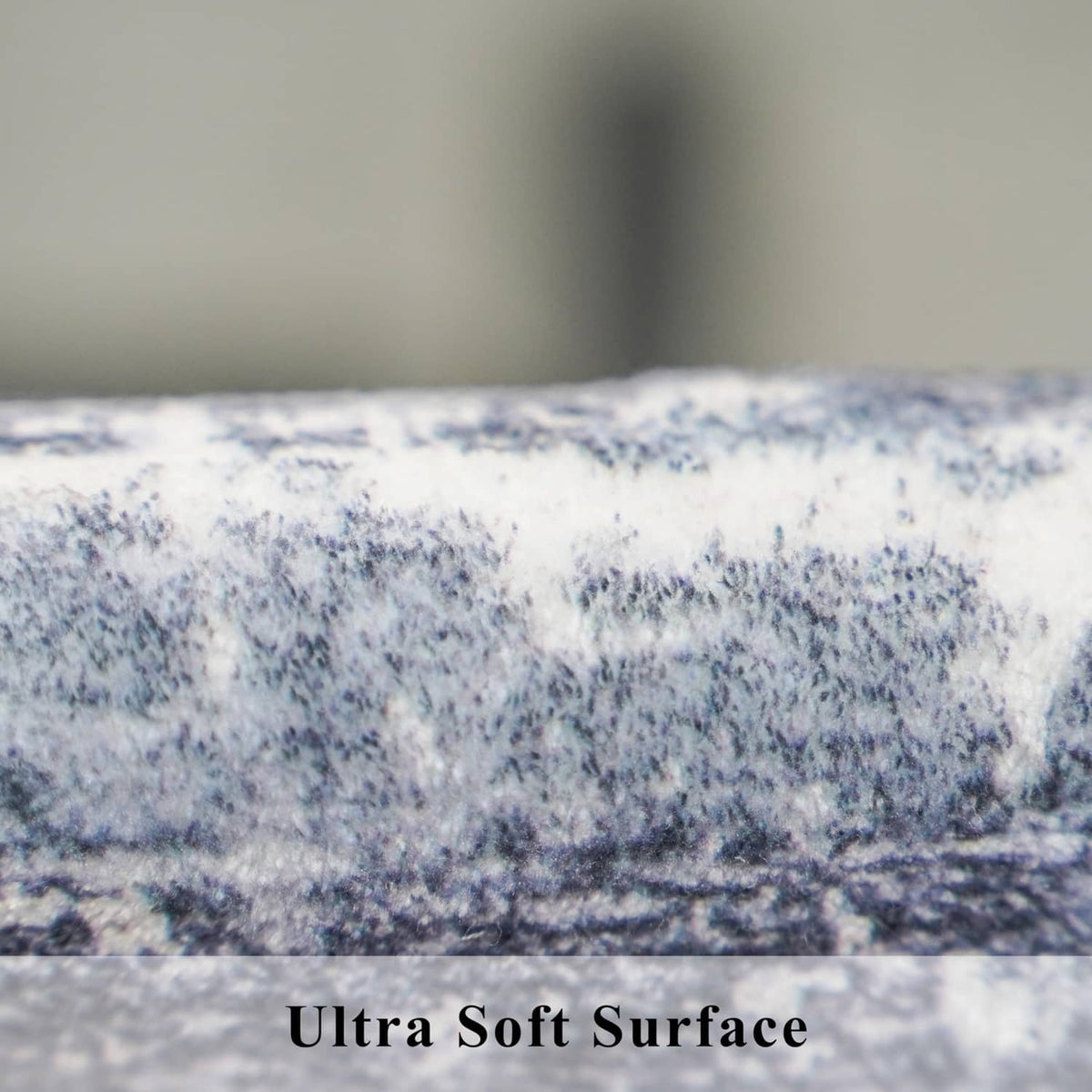 Ultra-soft surface of blue and ivory rug with mottled, distressed texture close-up.