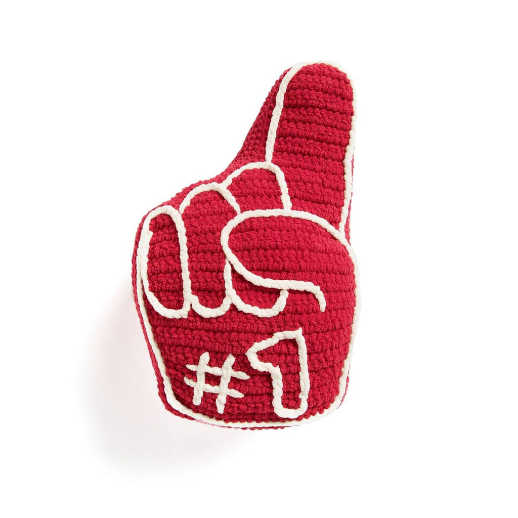 Red crocheted item with white outline and decorative heart-like pattern
