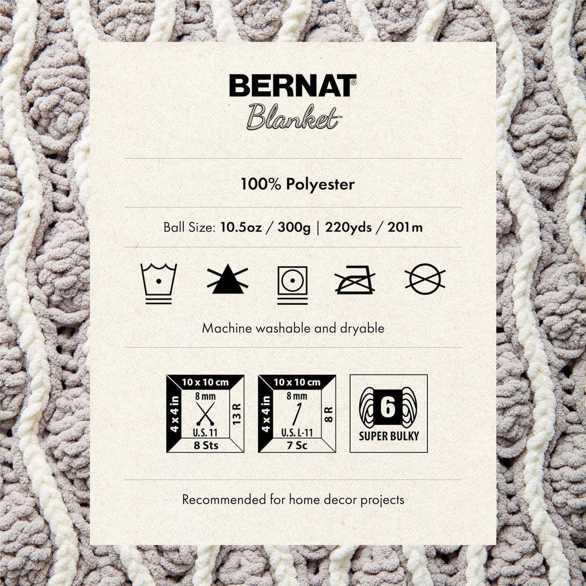 Fabric label card on textured cream crochet blanket, Bernat Blanket product details