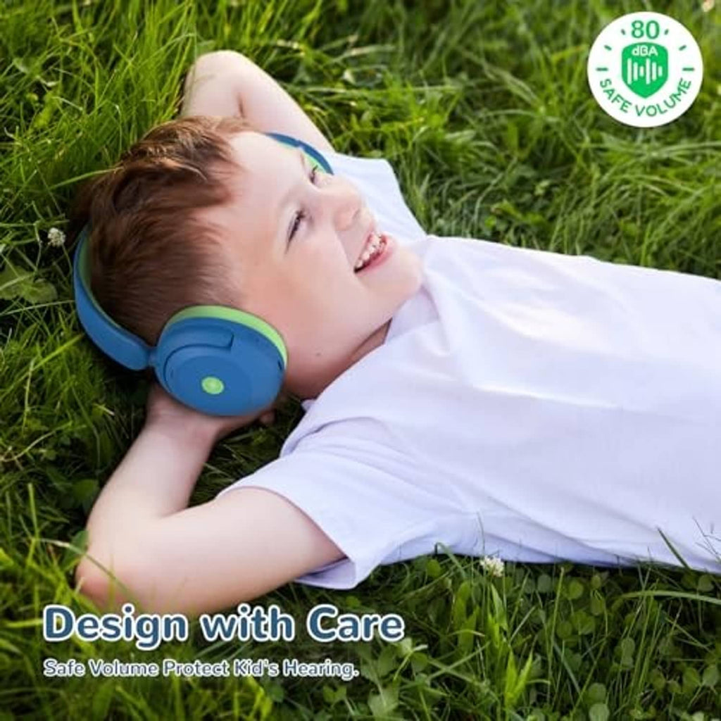 Kid wearing blue and green over-ear headphones while lying on grass
