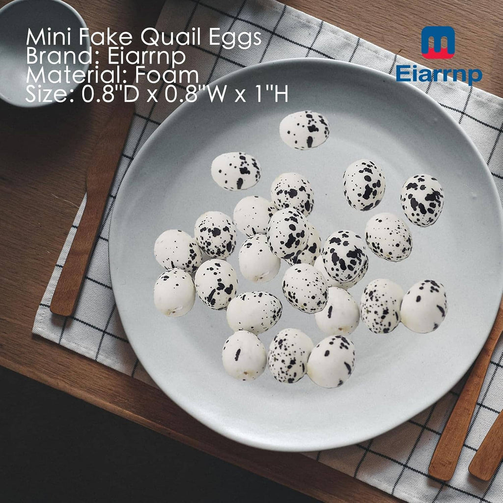 Artificial quail eggs on white plate, white shells with black speckles