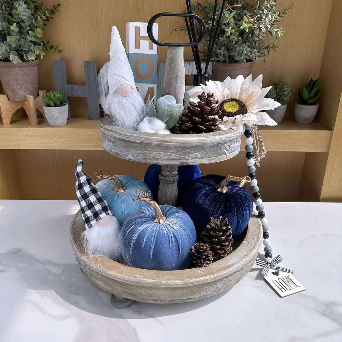 Blue faux velvet pumpkins with gold stems and hanging loops on a decorative tray centerpiece