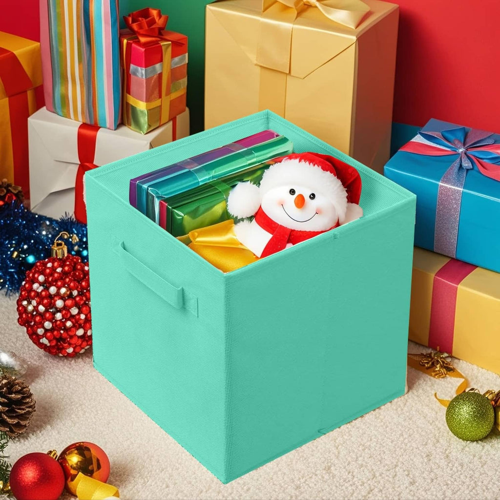 Mint green foldable fabric storage cube with handle, holding a plush snowman