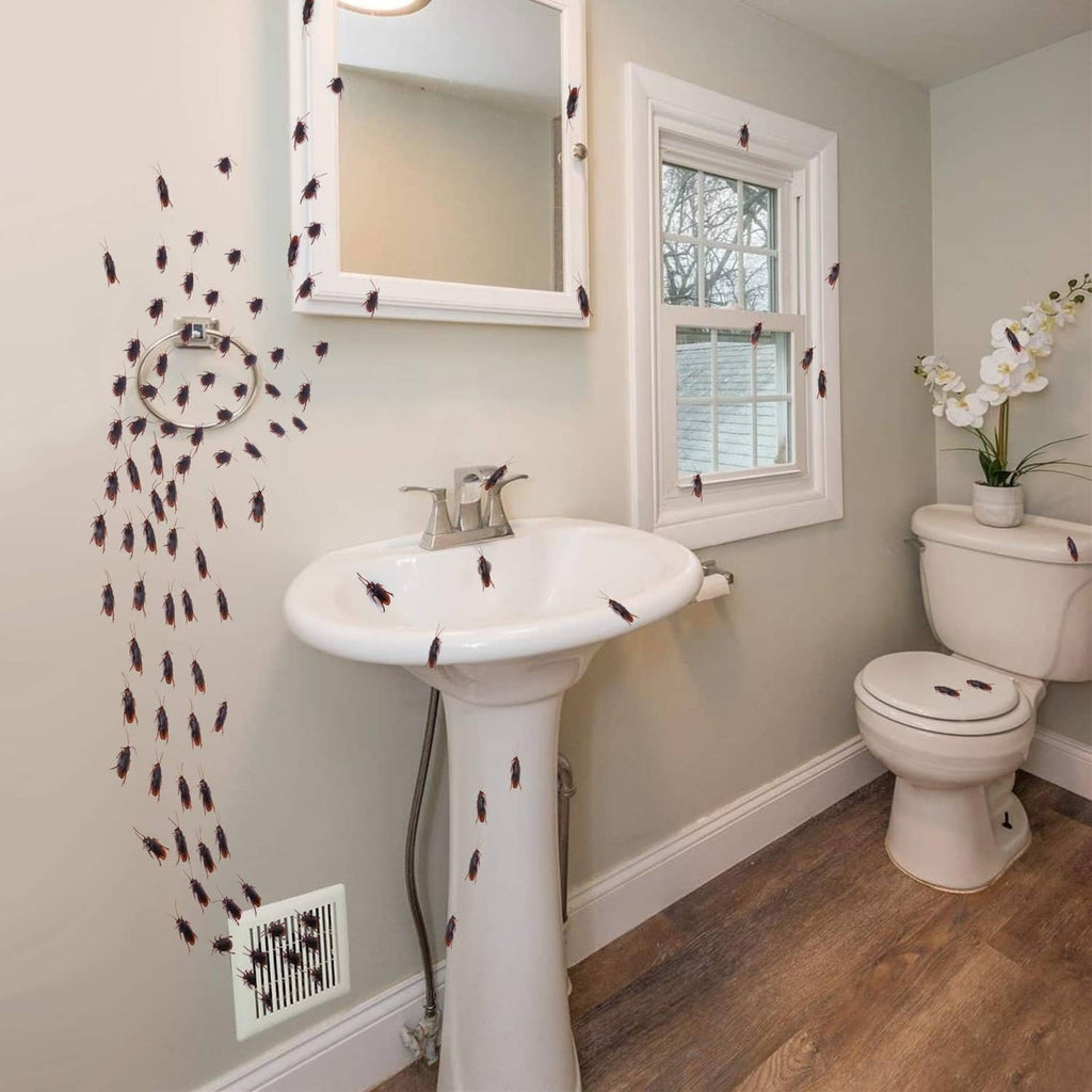 Fake bug wall decals scattered around a bathroom sink and toilet area