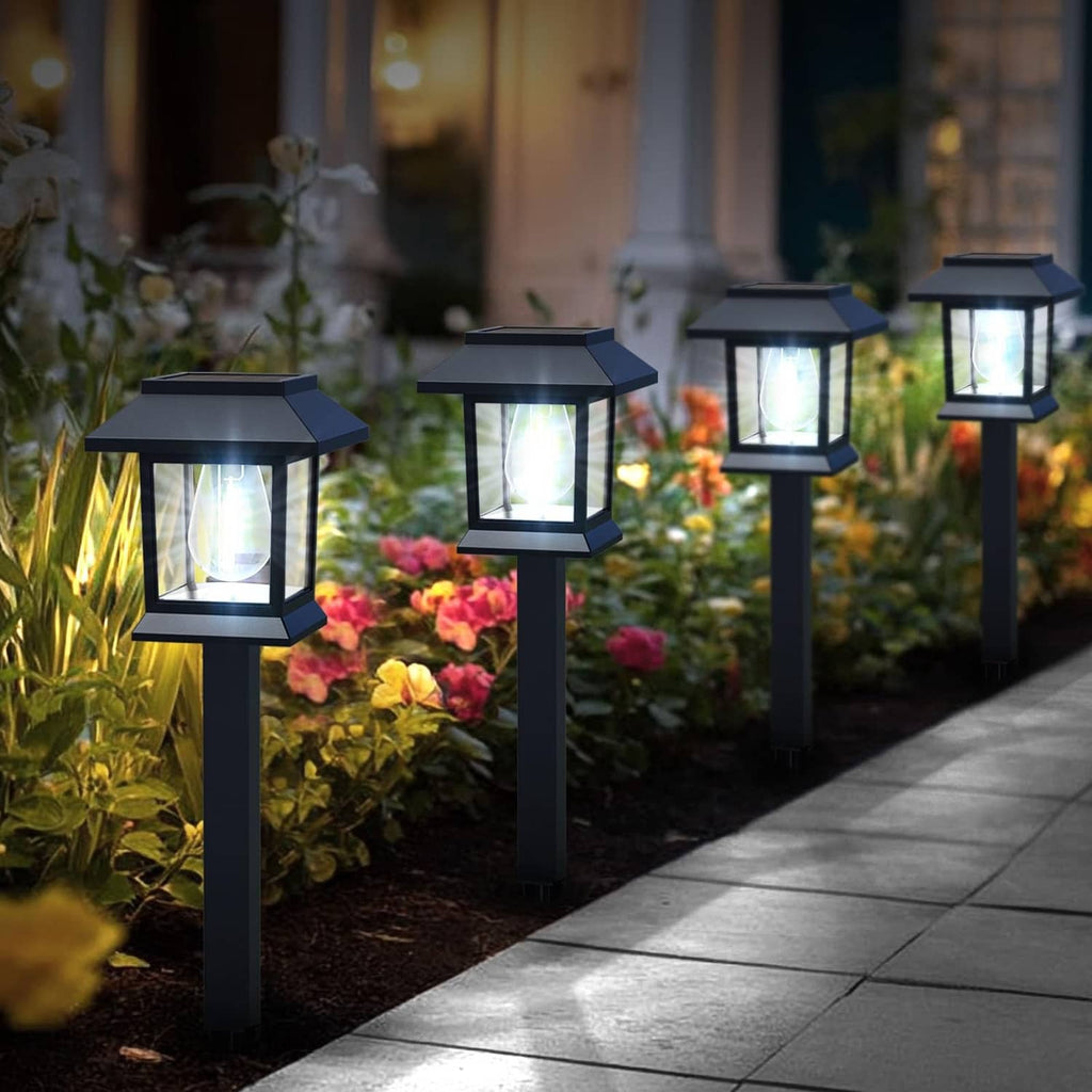 Outdoor solar pathway lights, black lantern tops on tall spikes, cool white glow