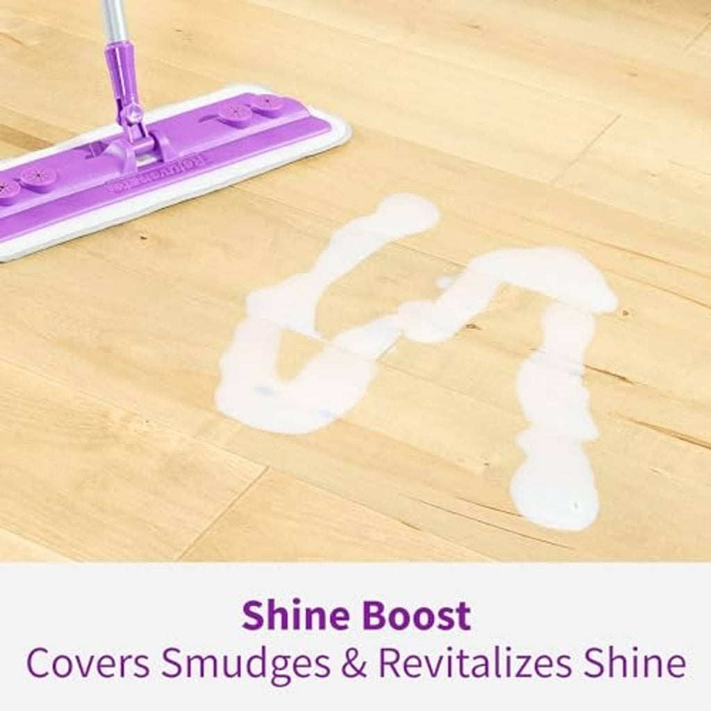 Purple mop pad spreading white floor polish on light wood planks