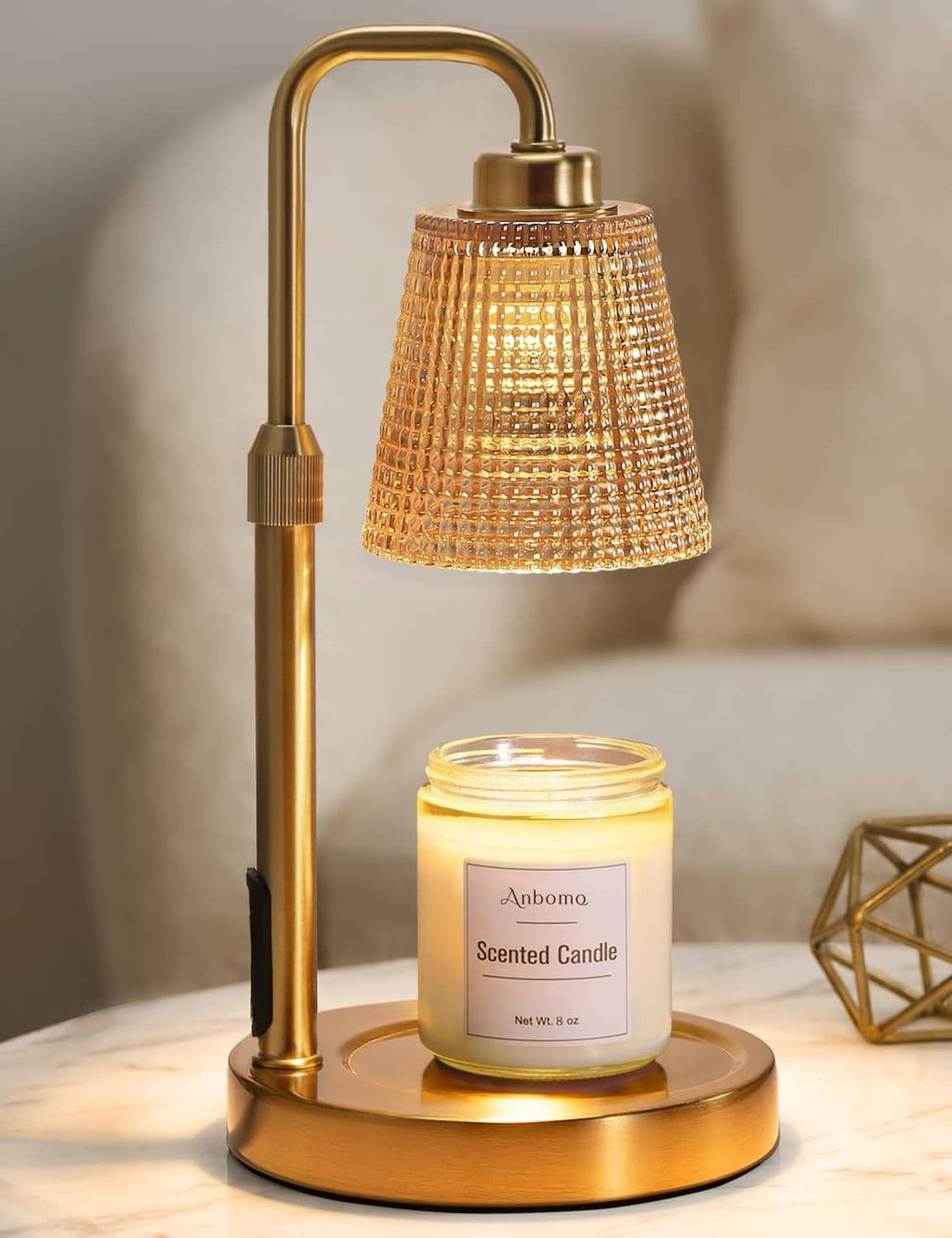 Gold candle warmer lamp with amber glass shade and scented jar candle on base